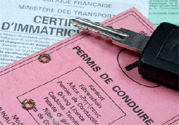 Permis de conduire rose, certificat d'immatriculation et clé de voiture posés.