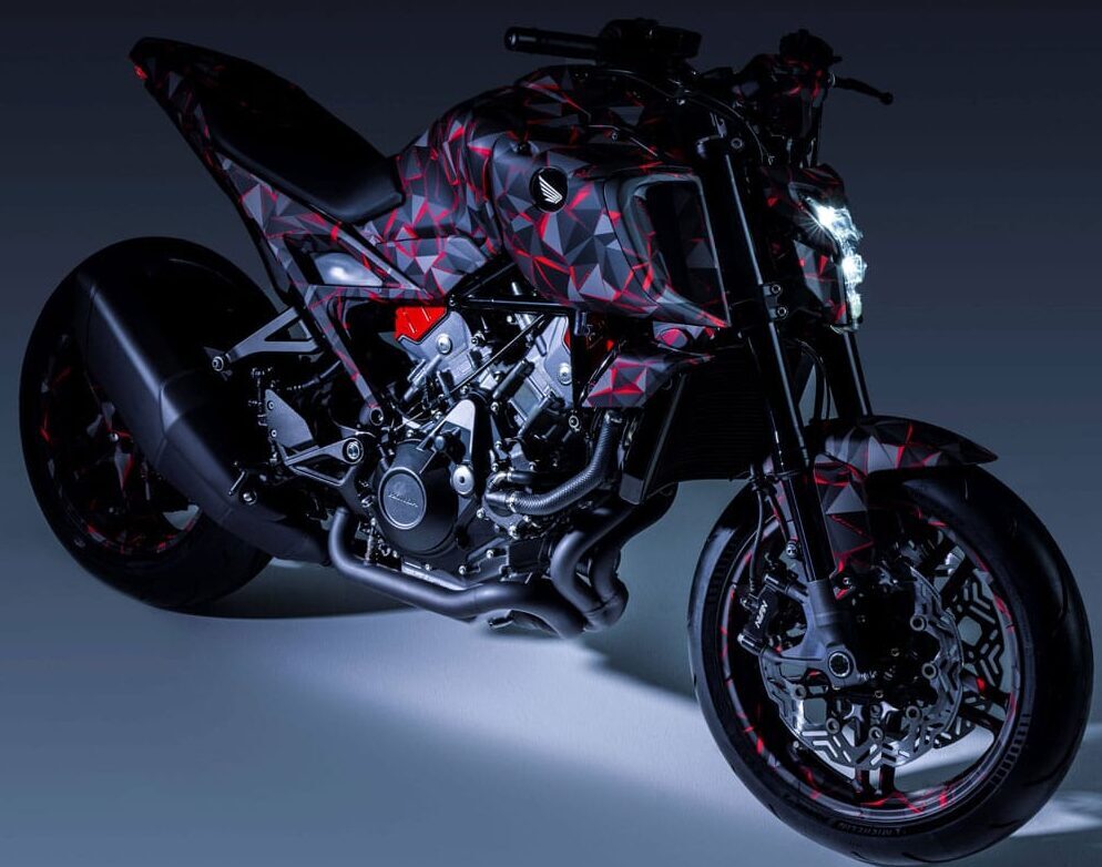 Moto Honda au look agressif avec covering géométrique rouge et noir, éclairage studio dramatique.